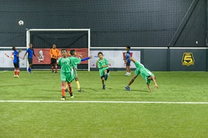 Children hapily playing football on a footfive playground